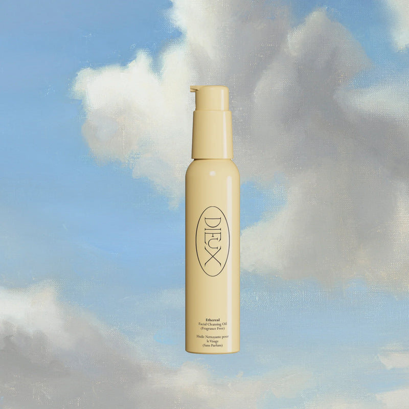 Dieux Ethereal Cleansing Oil bottle floating against clouds