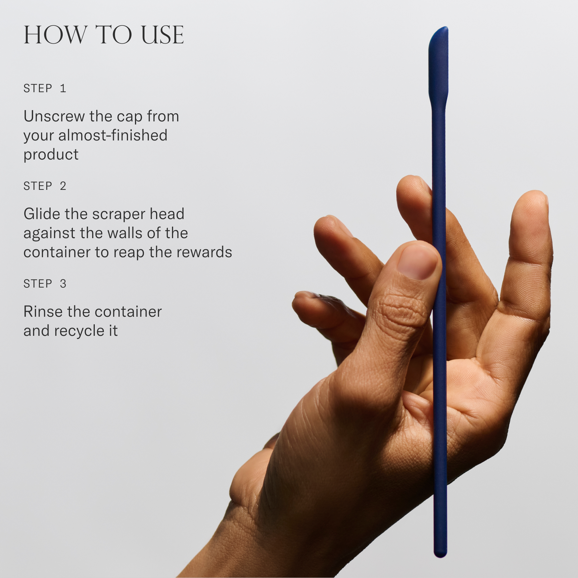 Hand holding a Skincare Scraper with instructions on how to use it on a light gray background