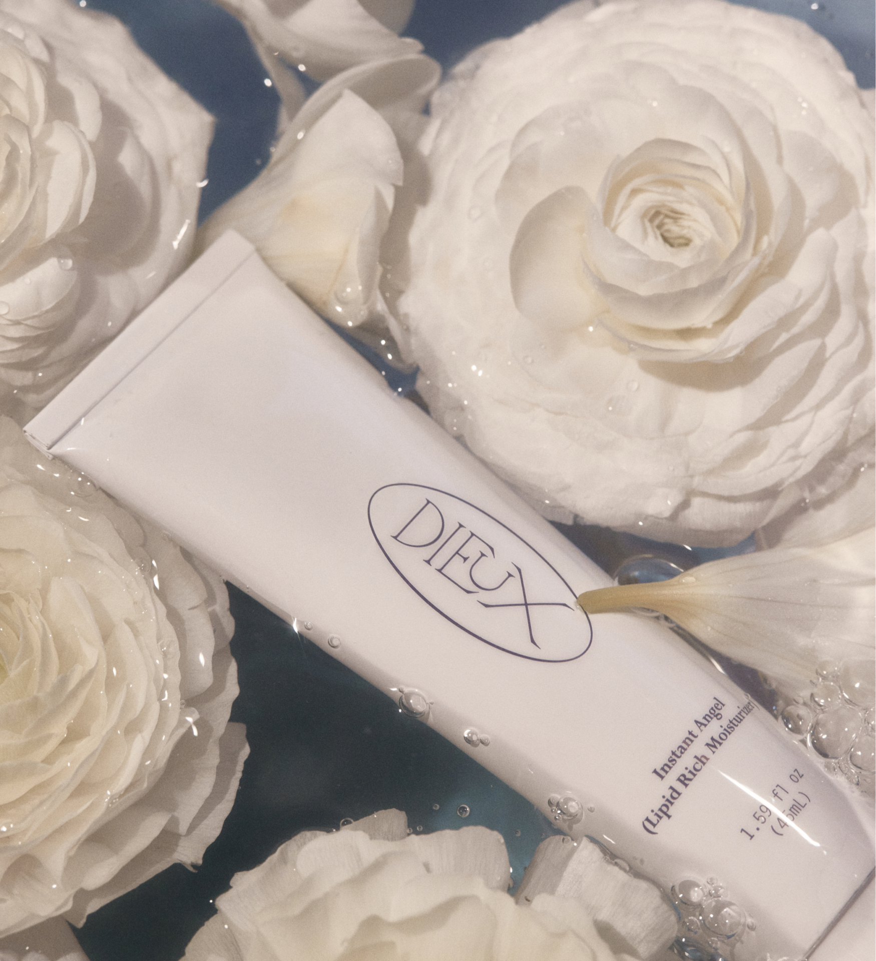 Instant Angel moisturizer tube on white flowers