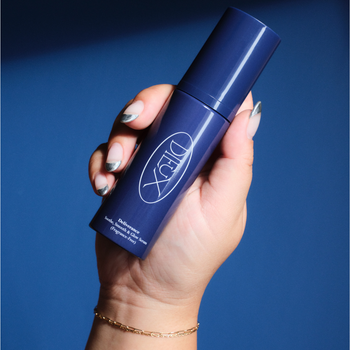 Hand holding a Dieux Deliverance aluminum bottle
