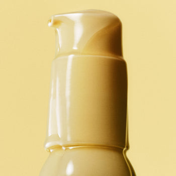 Close-up of Ethereal Cleansing Oil bottle on yellow background