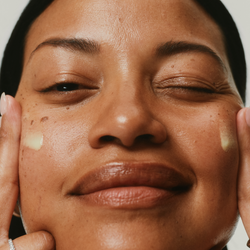 Woman applying Firm Revival HydroRetinal Firming Serum on her cheeks