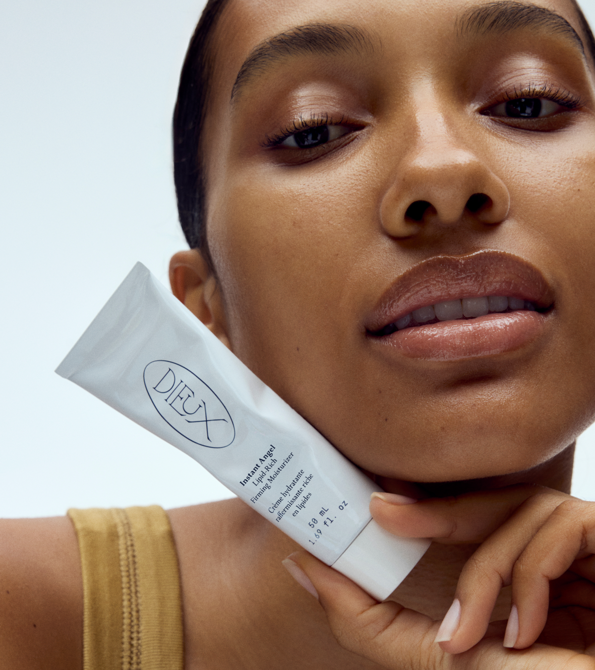 dieux Dieux-instant-angel-lipid-rich-firming-moisturizer-tube-held-near-chin.