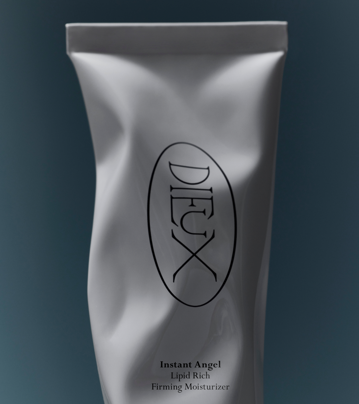 dieux Dieux-skin-instant-angel-lipid-rich-firming-moisturizer-squeeze-tube-on-dark-blue-background.